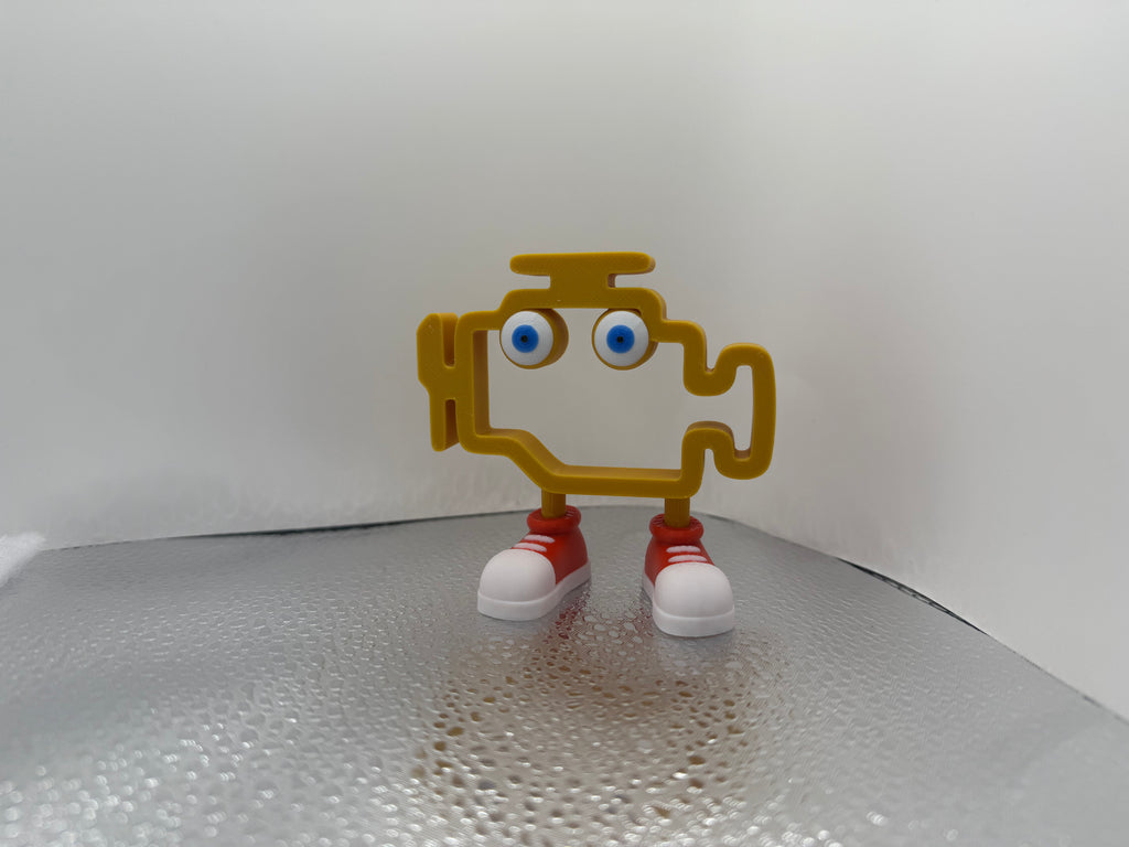 Small figurine with a yellow body, blue eyes, red shoes on a white background