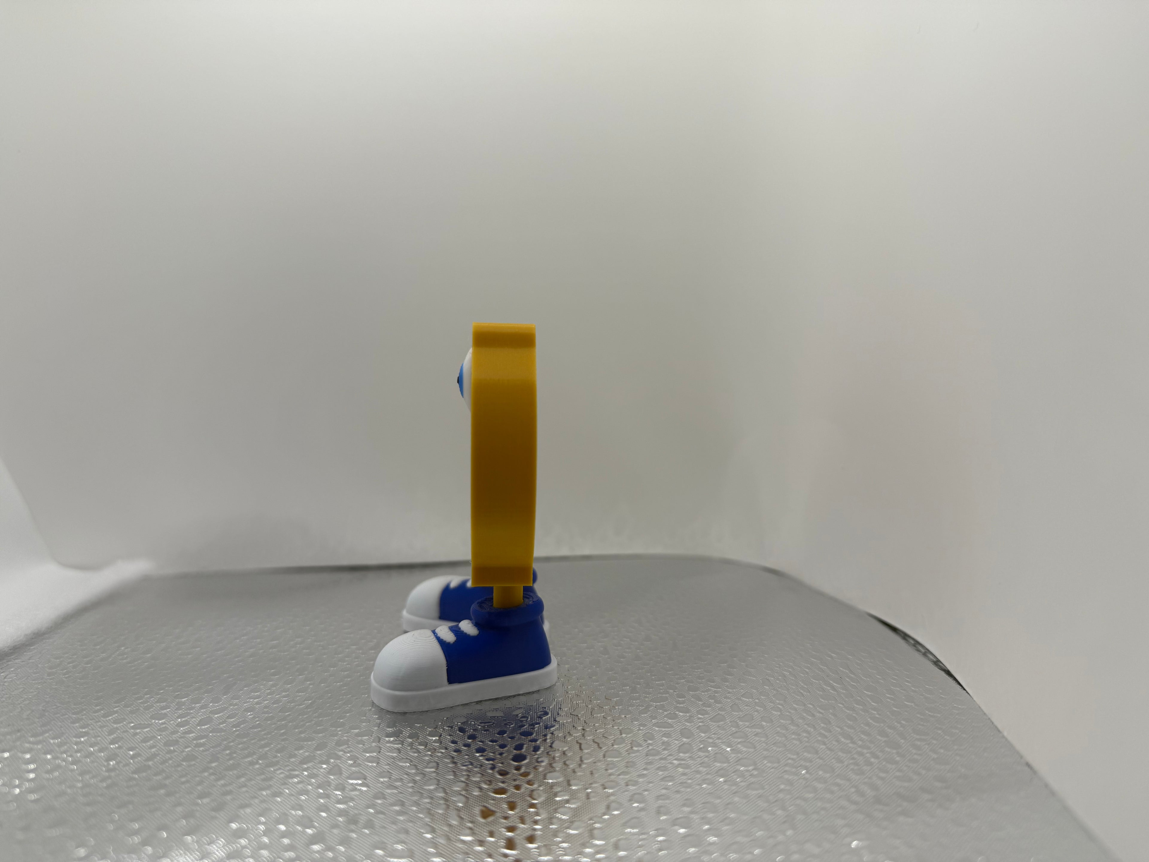 Small blue and white shoe with a yellow tag on a textured surface